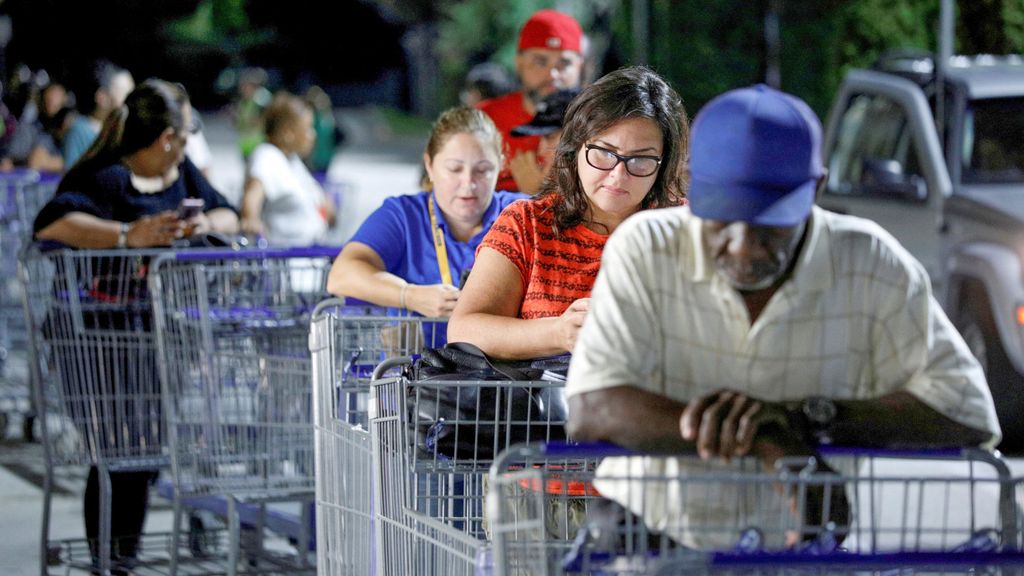 Shoppers wait in line for supplies before sunrise ahead of the arrival of Hurricane Dorian in Kissimmee