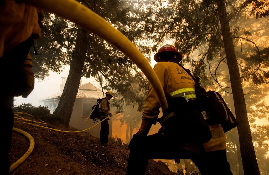 Firefighters battle a wildfire near a structure while defending the Mount Wilson observatory during the Bobcat Fire in Los Angeles