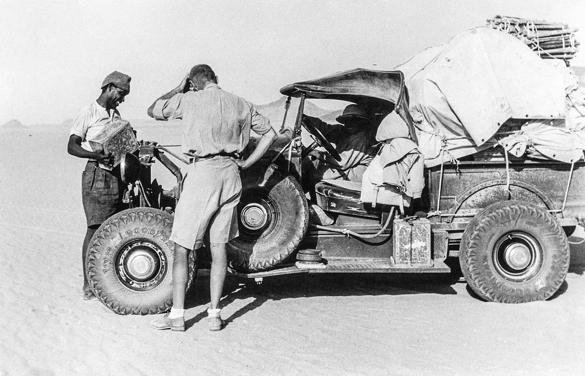 Libya Exploring expedition of the Count Laszlo Almasy, the british Wingcommander Hubert Penderell and the hungrian Dr. Kadar through the Libyan Desert: The loaded car, men at the bonnet (Series: 34 pictures) - ca. 1934 - Photographer: Hans G. Caspari