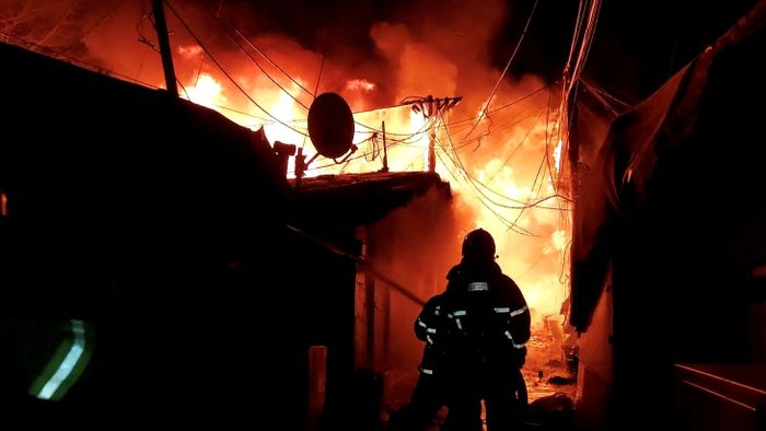 Firefighters work to put out the fire at Guryong village in Seoul