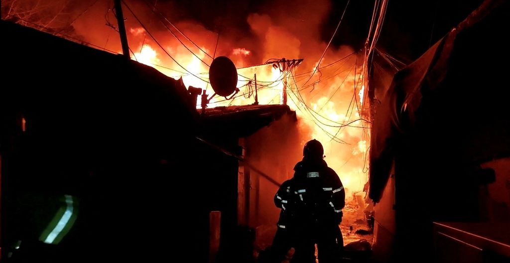 Firefighters work to put out the fire at Guryong village in Seoul