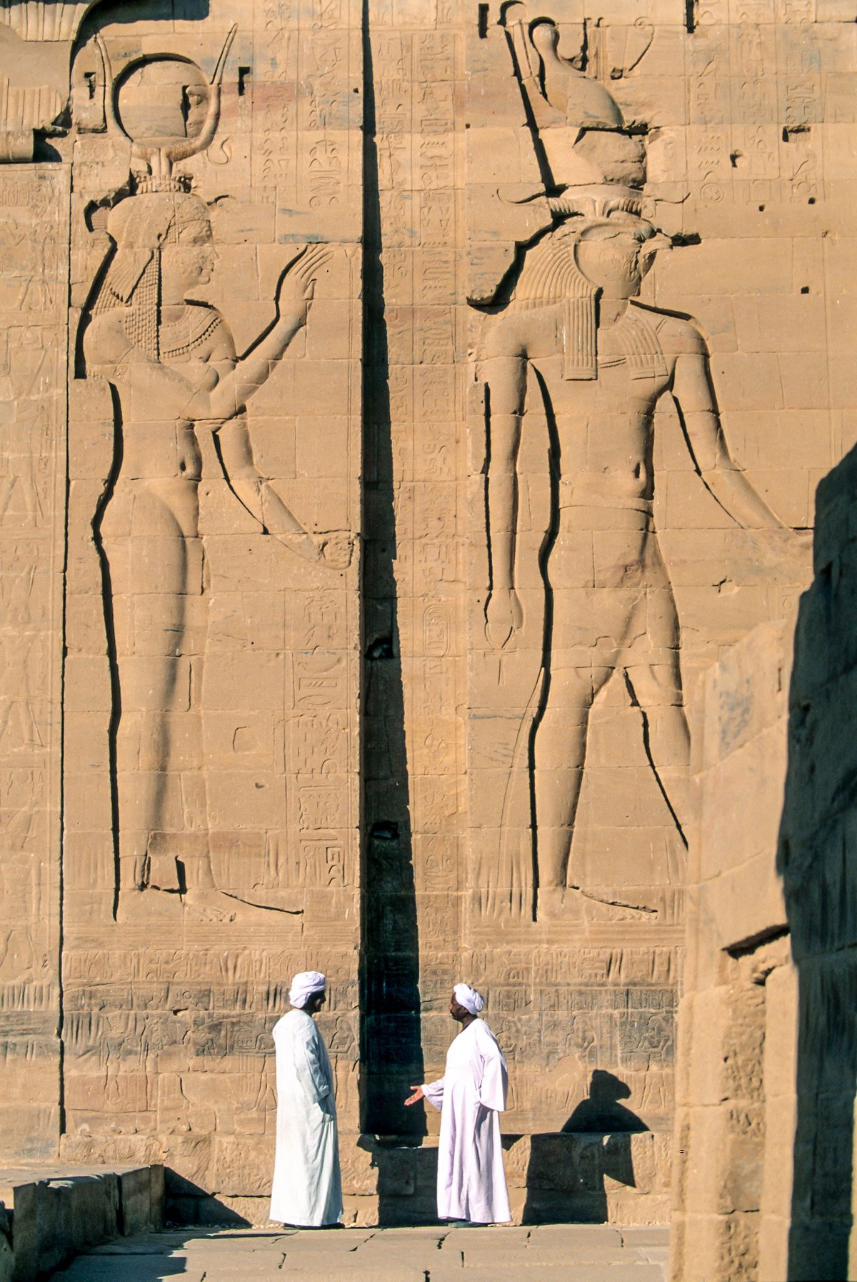 Egypt, Aswan region, the temple of Philae (temple of Isis), the entrance pylon; 2 men talking