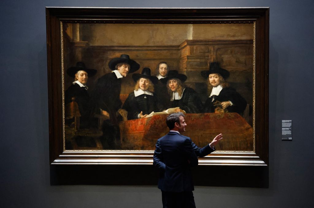 Emmanuel Macron francia elnök Rembrandt A posztós céh elöljárói című festménye előtt az amszterdami Rijskmuseumban kétnapos hollandiai látogatása során, április 12. Fotó: AFP/Ludovic Marin