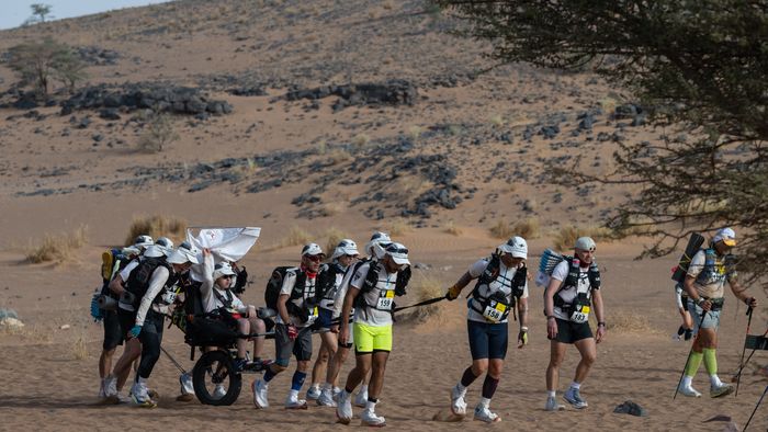 A 13 éves francia Enzót viszik társai a 37. Marathon des Sables 250 kilométeres szaharai ultramaraton harmadik szakaszán a marokkói sivatagban, április 25. A fiú álma volt részt venni a versenyen. Fotó: AFP/Jean-Philippe Ksiazek