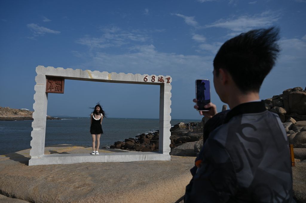 Fotózkodás betonkeretben a Pingtan-sziget tengerpartján, amely a Kínai Népköztársaság Tajvanhoz legközelebb eső pontja, április 8. Fotó: AFP/Greg Baker