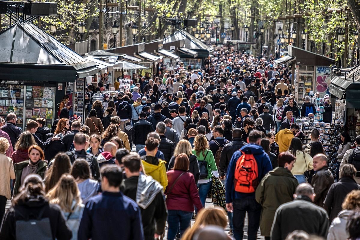 A crowd of people are seen strolling down the Ramblas in