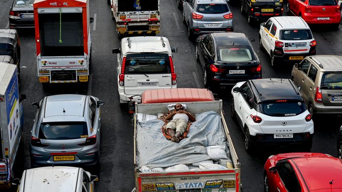 Teherautó rakományán szunyókáló indiai munkás a mumbai dugóban, április 25. Fotó: AFP/Indranil Mukherjee