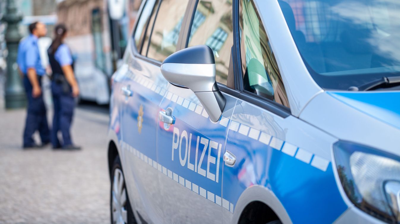 German,Police,Car,Stands,On,Street.,Two,Police,Officers,Controls