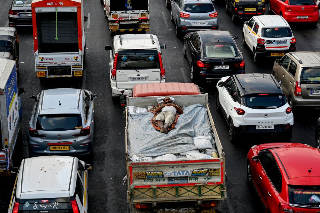 Teherautó rakományán szunyókáló indiai munkás a mumbai dugóban, április 25. Fotó: AFP/Indranil Mukherjee