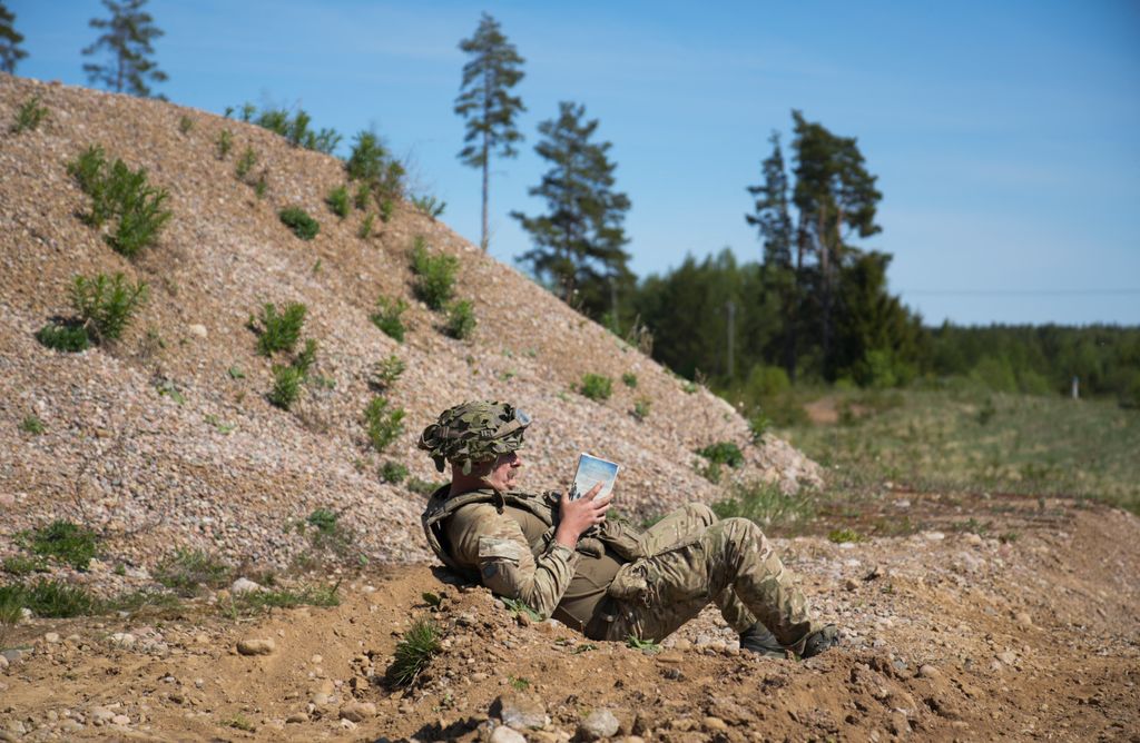 Brit katona könyvet olvas az észtországi Sakussaare-ben tartott NATO-hadgyakorlaton, május 20. 