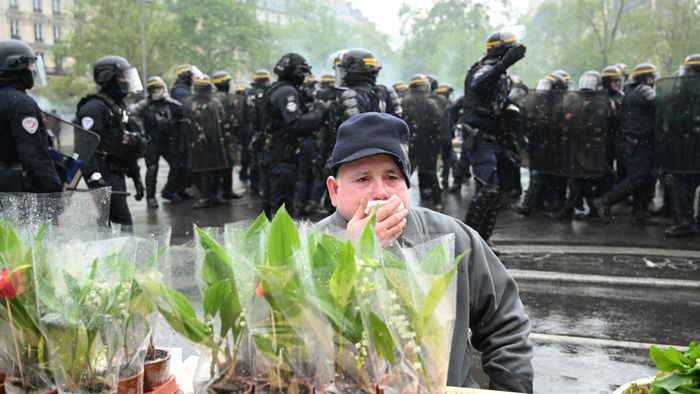 Párizsi gyöngyvirágárus könnygázban a május 1-ji tüntetésen, amelyet a francia nyugdíjreform elleni tiltakozásul szerveztek, május 1. Fotó: Fotó: AFP/Alain Jocard 