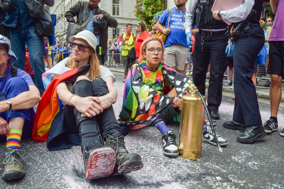 Protesters sit and block the road during the demonstration