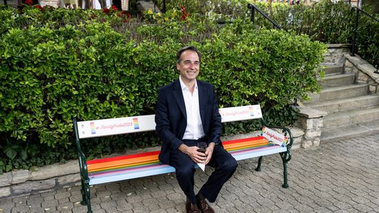 Pressman poses on replica of 9th district LGBTQ bench