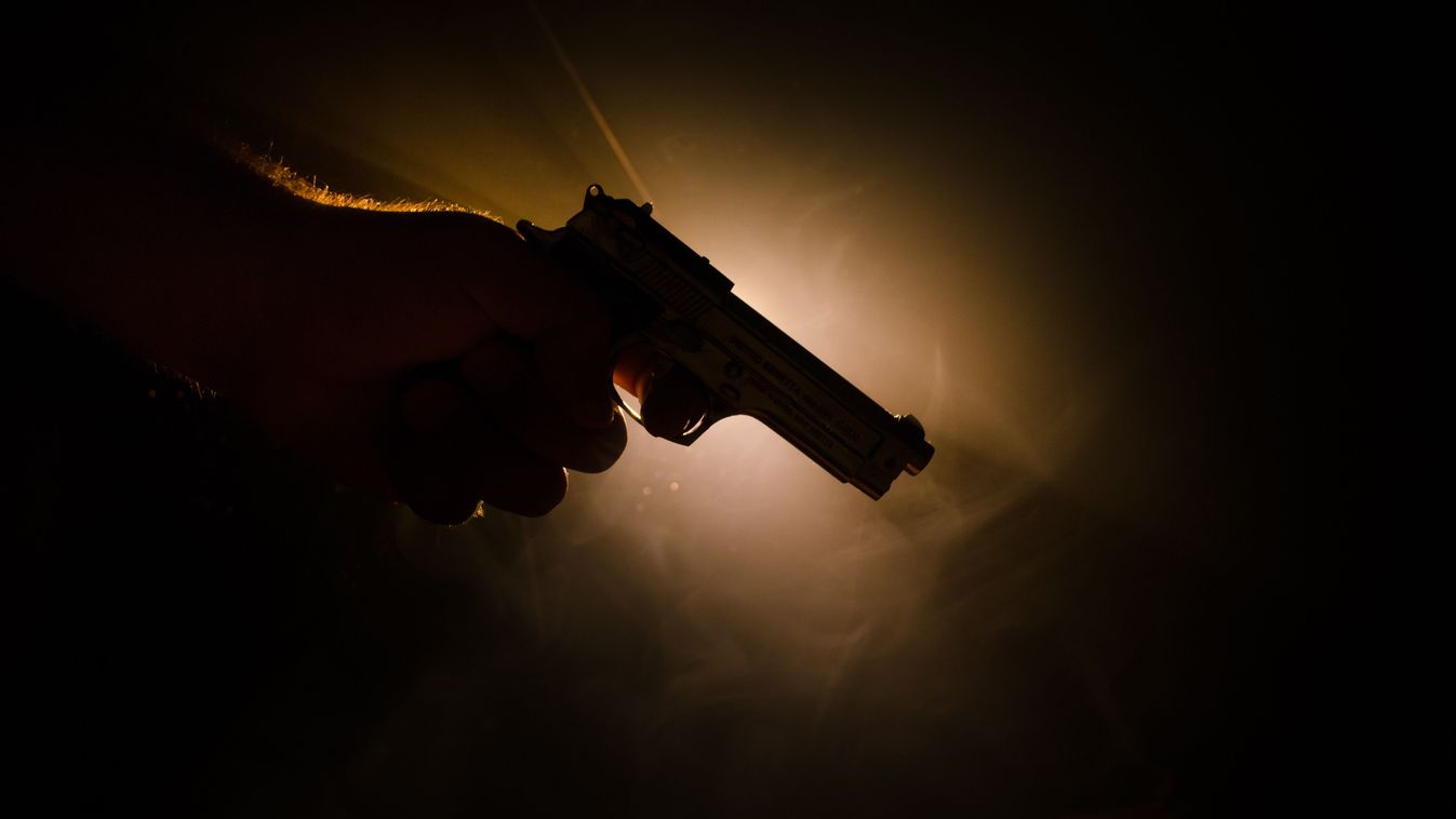 Male,Hand,Holding,Gun,On,Black,Background,With,Smoke,(