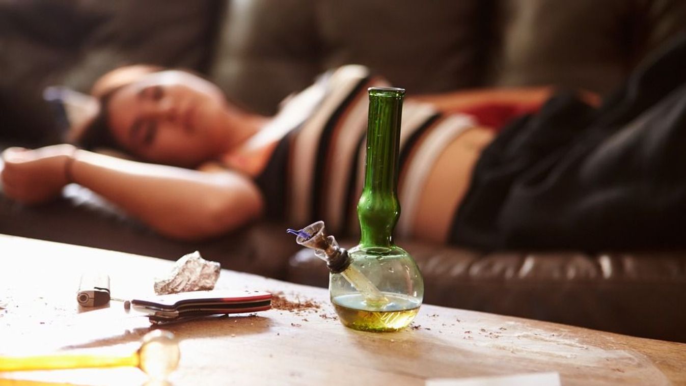 Woman,Slumped,On,Sofa,With,Drug,Paraphernalia,In,Foreground