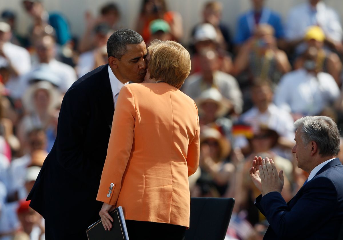 U.S. President Obama kisses German Chancellor Merkel as Berlin Mayor Wowereit applauds at the Brandenburg Gate in Berlin