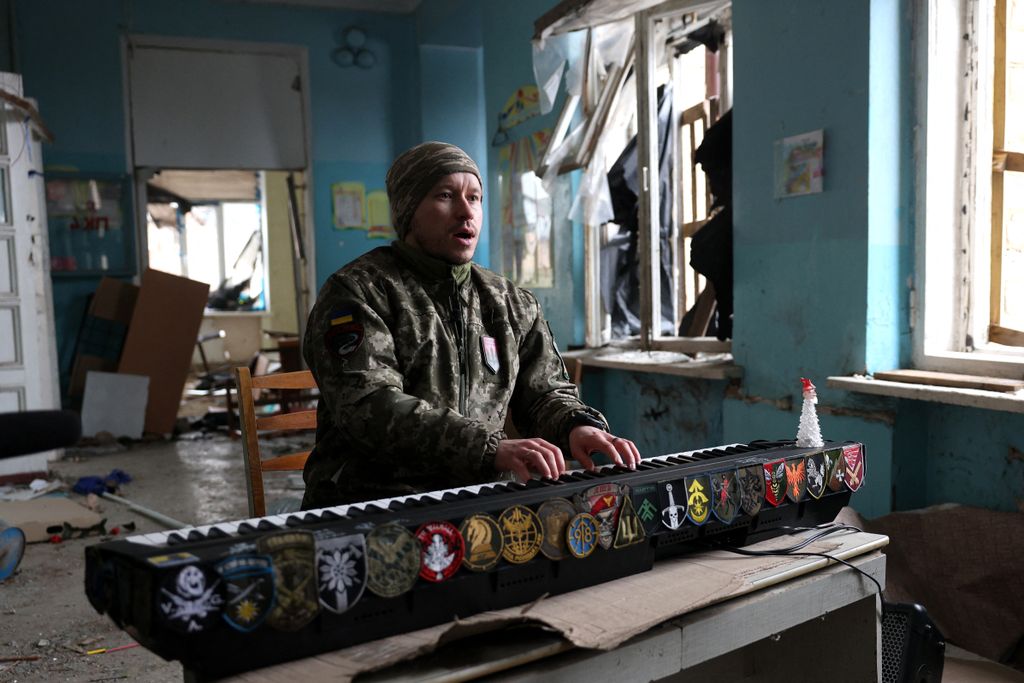Egy ukrán katona zongorázik egy rakétatámadás következtében lerombolt iskolaépületben Kosztjantyinivka városában