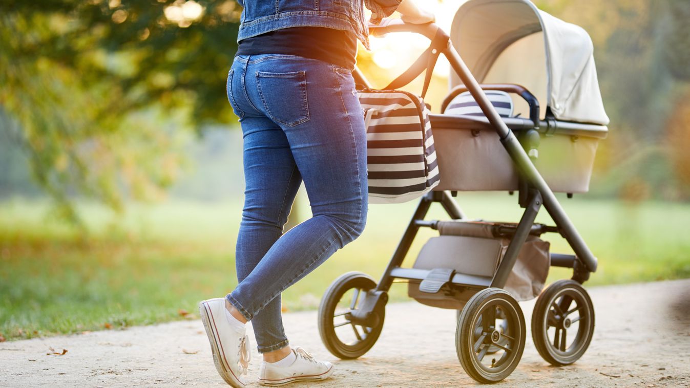 Woman,With,Baby,Stroller,Walks,In,The,Park,At,Sunset