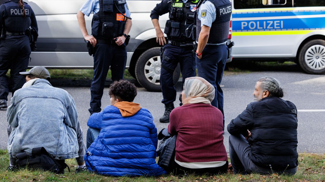 A group of migrants waits on the side of the road as they are controlled by officers of the German Federal Police (Bundespolizei) near Forst, eastern Germany on October 11, 2023, during a patrol near the border with Poland. (Photo by JENS SCHLUETER / AFP) / ACCORDING TO INSTRUCTIONS OF THE FEDERAL POLICE, ALL POLICE OFFICERS AND MIGRANTS MUST BE MADE UNRECOGNIZABLE
