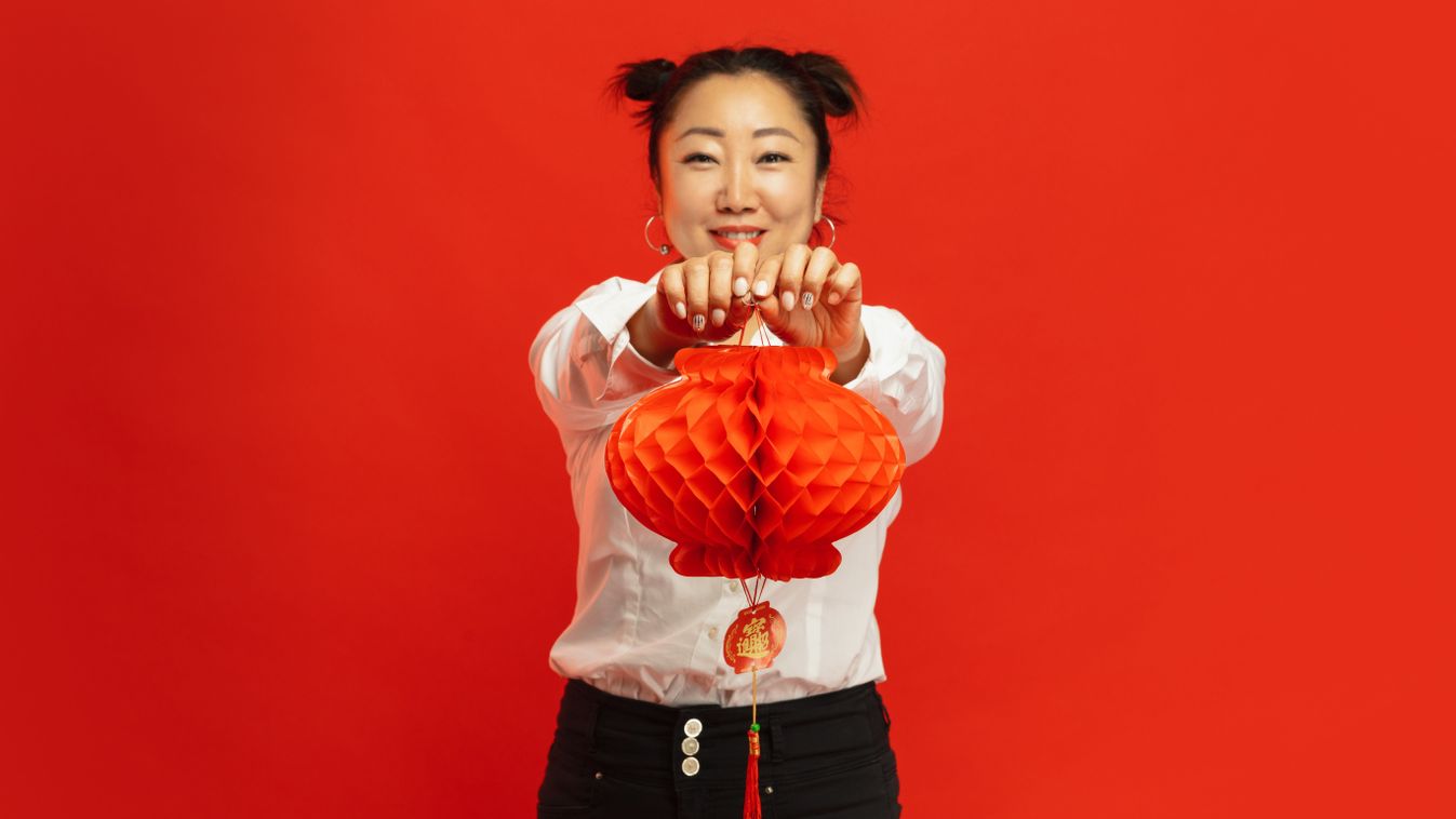 Happy Chinese New Year. Asian young woman portrait isolated on red background