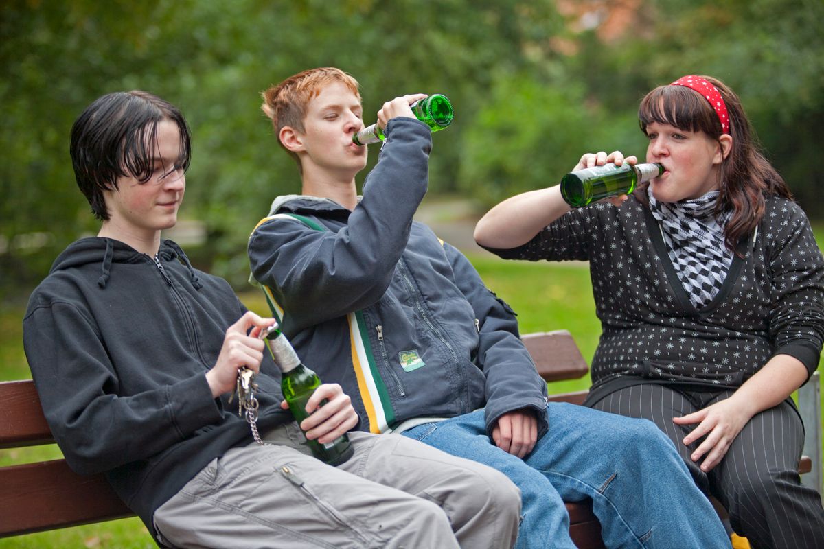 three teenagers drinking beer at a park / youth / problem