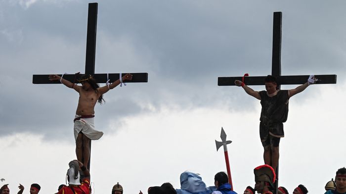 Philippine Christian devotee Ruben Enaje (L) performs his 35th re-enactment of the crucifixion of Jesus Christ on Good Friday in San Fernando, Pampanga province on March 29, 2024. (Photo by JAM STA ROSA / AFP)