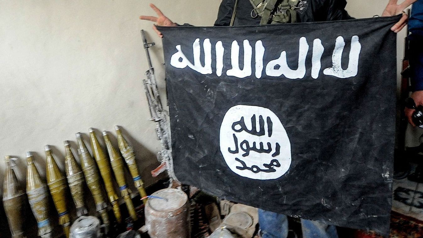 Kurdish Defenders Show Islamic State Flag Captured In Battle Along With Weapons Cache