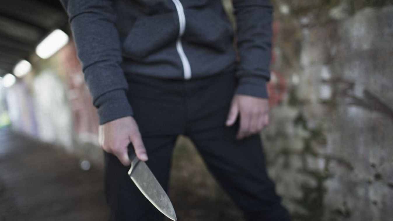 Young man holding knife weapon in tunnel