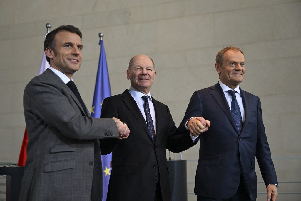Olaf Scholz német kancellár (C), Emmanuel Macron francia elnök (L) és Donald Tusk lengyel miniszterelnök (R) kezet fognak, miközben fényképezés közben pózolnak, miután közös sajtótájékoztatót tartottak a találkozójukat követően Berlinben,  2024. március 15-én. (Fotó: Anadolu via AFP/ Halil Sagirkaya)