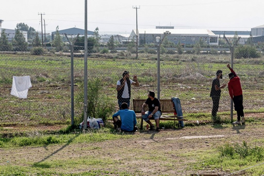 A szír menekültek 2019. november 5-én a ciprusi fővárostól, Nicosiától mintegy 20 kilométerre lévő Kokkinotrimithia ideiglenes szállásadó központja kerítésen túlról beszélnek barátaikkal és családtagjaikkal. (Fotó: AFP/Iakovos Hatzistavrou)