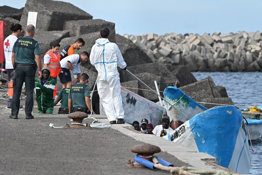 A migránsokat a Spanyol Vöröskereszt és a Guardia Civil tisztek segítik le a csónakról, miután a spanyol Salvamento Maritimo (Tengeri Kutató- és Mentőügynökség) „Salvamar Adhara” hajója körülbelül 250 migránst mentett ki három különböző csónakon a tengeren, La Restinga kikötőjében. (Fotó: AFP/STRINGER)
