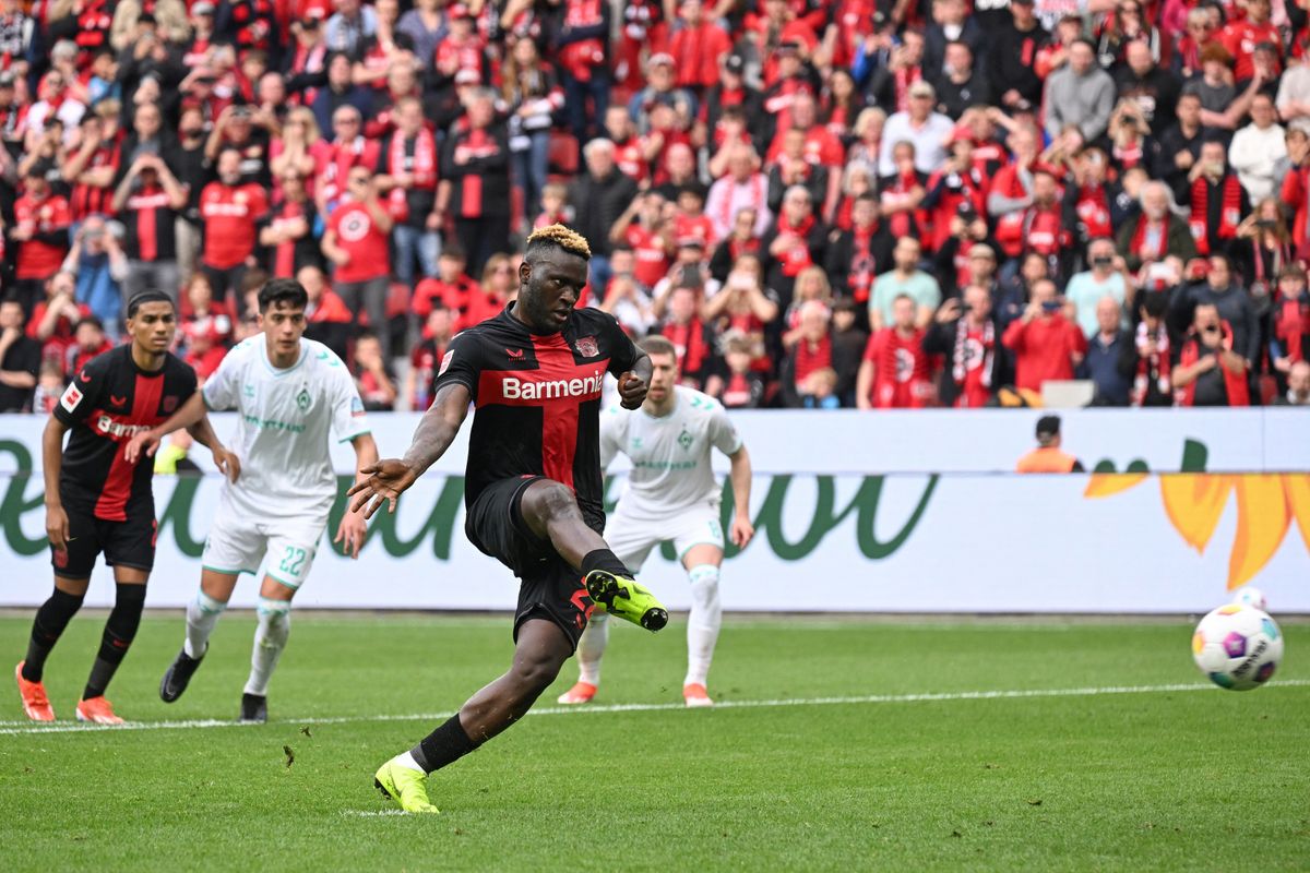 Bayer Leverkusen's Nigerian forward #22 Victor Boniface scores the opening goal from the penaty spot during the German first division Bundesliga football match Bayer 04 Leverkusen v Werder Bremen in Leverkusen, western Germany, on April 14, 2024. (Photo by INA FASSBENDER / AFP) / DFL REGULATIONS PROHIBIT ANY USE OF PHOTOGRAPHS AS IMAGE SEQUENCES AND/OR QUASI-VIDEO