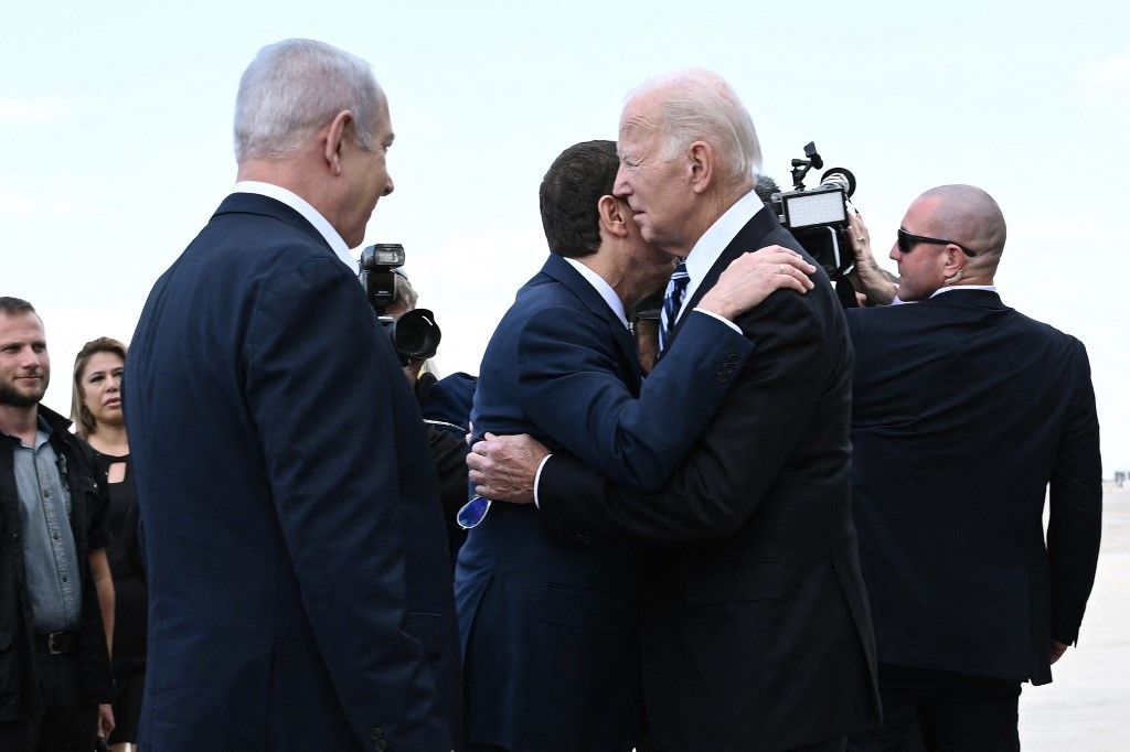 Benjamin Netanjahu (b) izraeli miniszterelnök azt nézi, ahogy Isaac Herzog izraeli elnök köszönti Joe Biden amerikai elnököt a tel-avivi Ben Gurion repülőtéren 2023. október 18-án, az Izrael és a Hamász palesztin csoport közötti harcok közepette. (Fotó: AFP/Brendan SMIALOWSKI)
