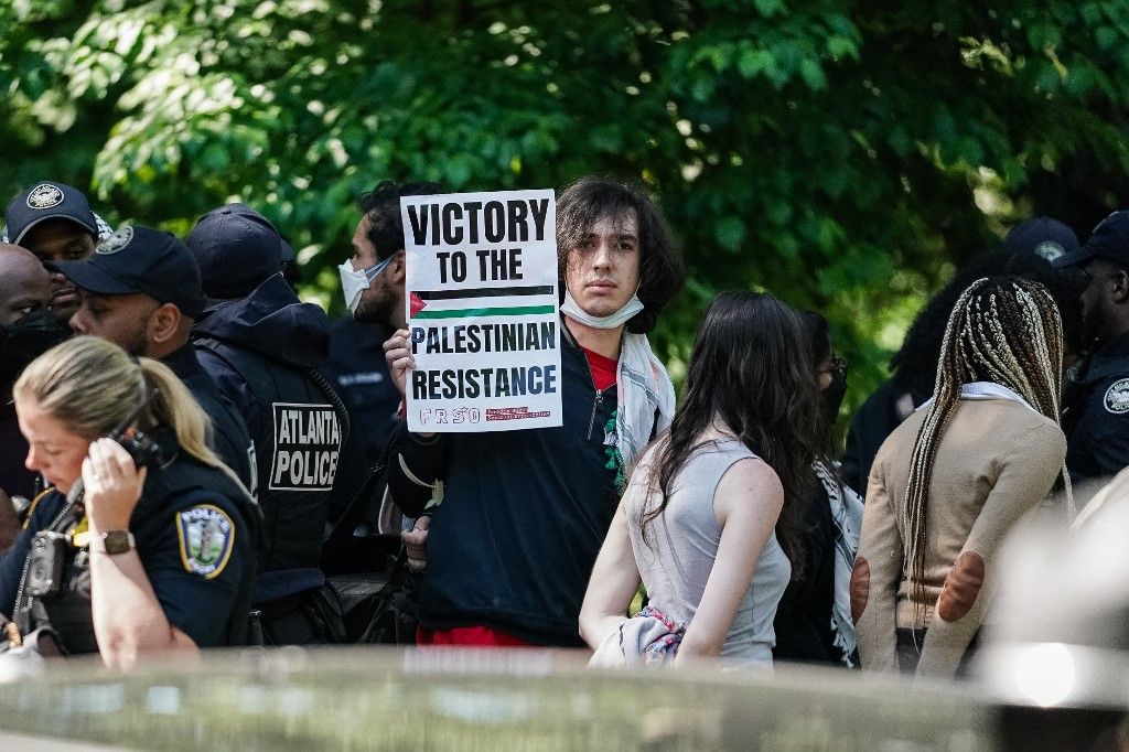 Egy őrizetbe vett tüntető táblát tart fel, miközben Izrael-ellenes diákok demonstrálnak az Emory Egyetemen 2024. április 25-én, Atlantában, Georgia államban. (Fotó: Elijah Nouvelage / AFP)
