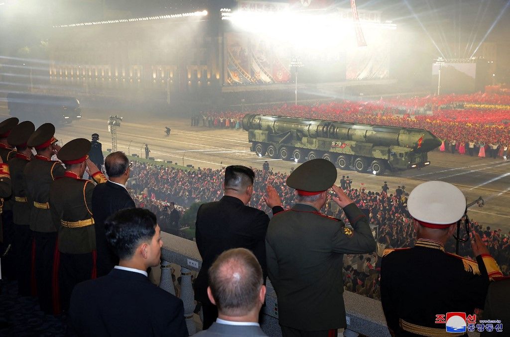 2023. július 28-án, Észak-Korea vezetője, Kim Dzsong Un (C fekete öltönyben) az interkontinentális ballisztikus rakéta (ICBM) új modelljét nézi. (Fotó: AFP/KCNA VIA KNS)