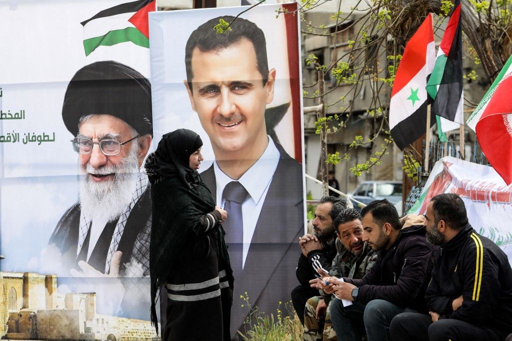 Bassár el-Aszad szíriai elnök és Ali Hamenei ajatollah iráni legfelsőbb vezető portréi. (Fotó: AFP/OUAI BESHARA)