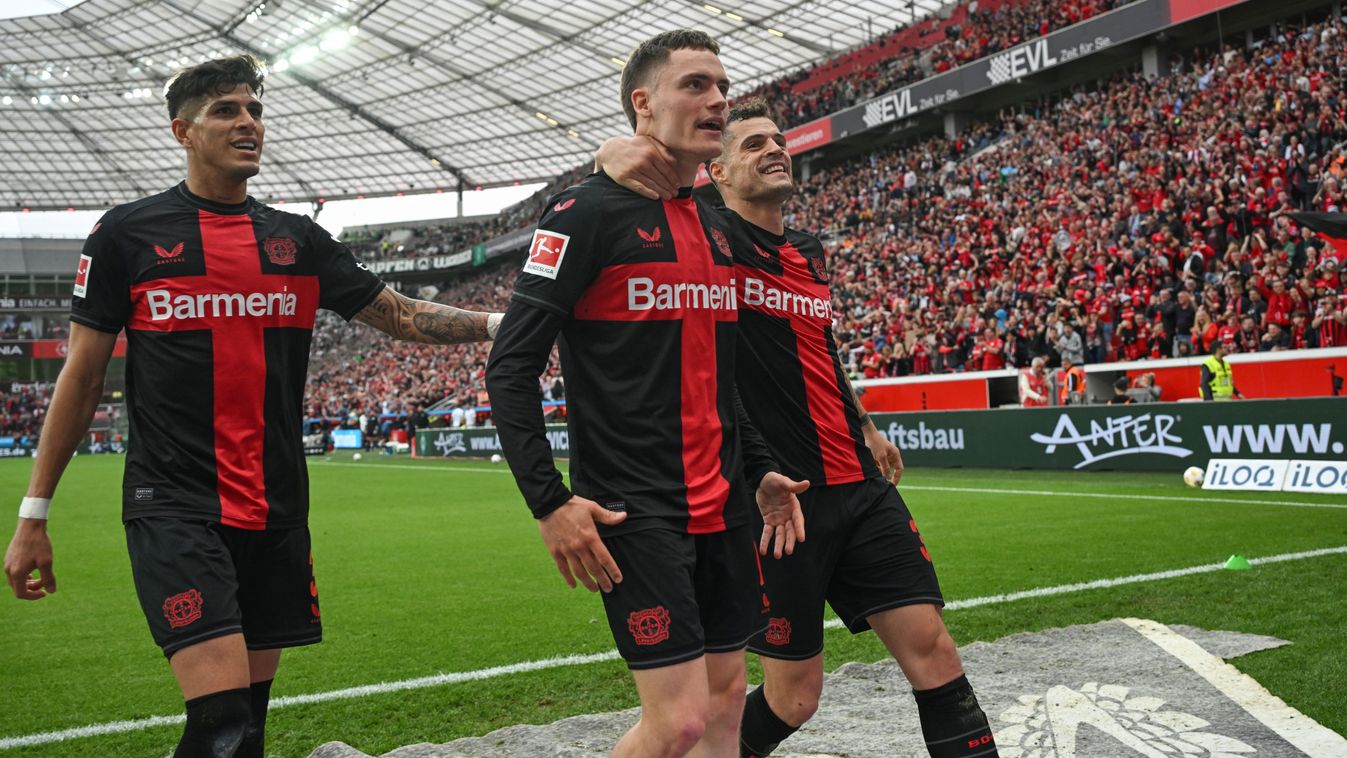 Bayer Leverkusen's German midfielder #10 Florian Wirtz (C) celebrates scoring the 3-0 goal with his team-mates Bayer Leverkusen's Swiss midfielder #34 Granit Xhaka (R) and Bayer Leverkusen's Ecuadorian defender #03 Piero Hincapie during the German first division Bundesliga football match Bayer 04 Leverkusen v Werder Bremen in Leverkusen, western Germany, on April 14, 2024. (Photo by INA FASSBENDER / AFP) / DFL REGULATIONS PROHIBIT ANY USE OF PHOTOGRAPHS AS IMAGE SEQUENCES AND/OR QUASI-VIDEO