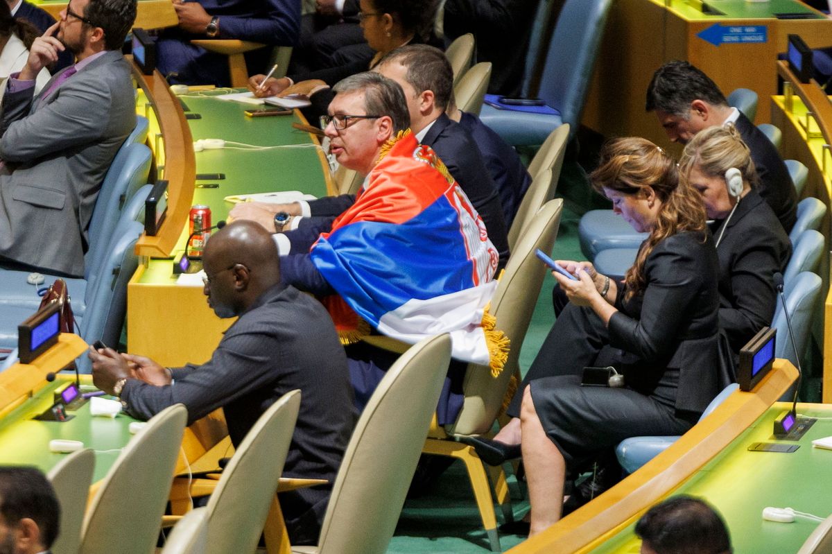 Alekszandar Vucsics szerb elnök hazája zászlaját magára terítve ül a szrebrenicai népirtás nemzetközi emléknappá nyilvánításáról rendezett szavazás végén az ENSZ Közgyűlésében, a világszervezet New York-i székházában 2024. május 23-án. A közgyűlés megszavazta, hogy az 1995-ös szrebrenicai népirtás nemzetközi emléknapja július 11. lesz. (Fotó: MTI/EPA/Sarah Yenesel)