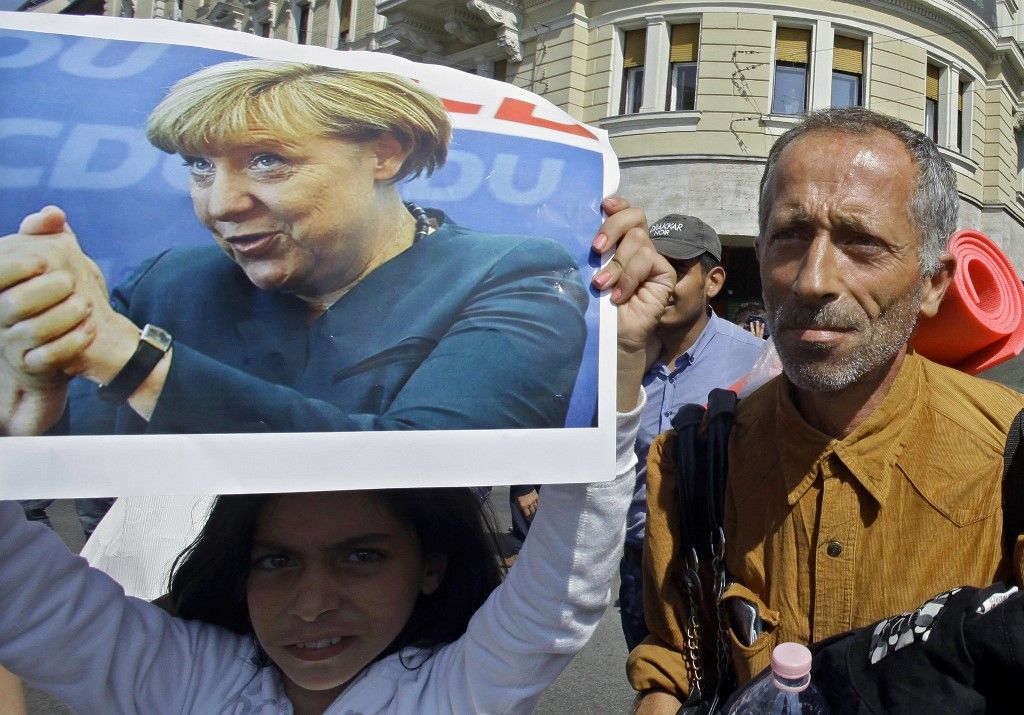 Angela Merkel német kancellár plakátját tartja kezében egy migránslány Budapest belvárosában 2015. szeptember 4-én. Brüsszel ránk erőltetné a migrációt. (Fotó: AFP PHOTO / KŐHALMI PÉTER)