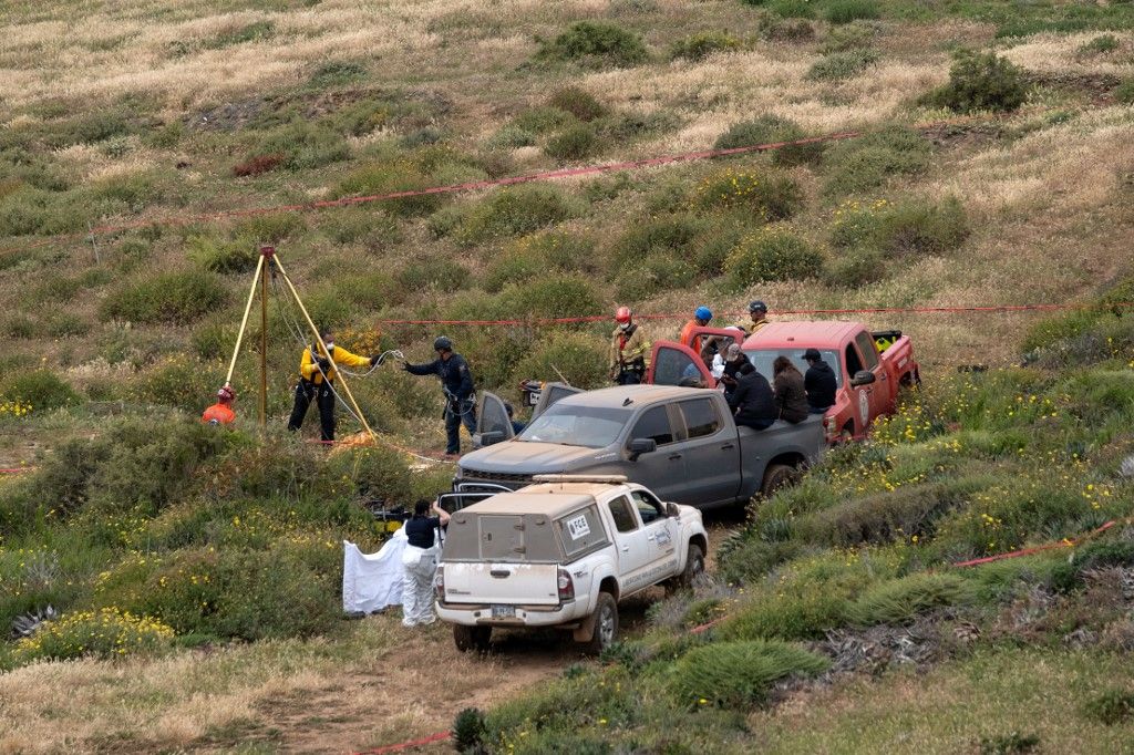 Mentősök, törvényszéki szakértők és ügyészek dolgoznak egy kútnál, ahol emberi maradványokat találtak a La Bocana Beach közelében Mexikóban. (Fotó: Guillermo Arias / AFP)