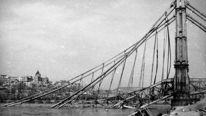 1945. Budapest V.
a lerombolt Erzsébet híd pesti hídfője az alsó rakpartról nézve, háttérben a romos Királyi Palota (később Budavári Palota).
Fortepan / Kramer István dr