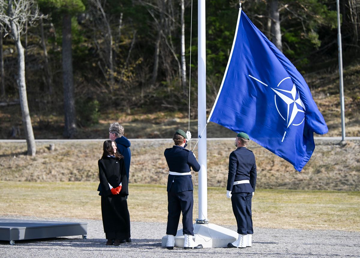 Svédország NATO-csatlakozásának jelképeként felvonják a NATO lobogóját Romina Pourmokhtari svéd klímaügyi miniszter (b) és Gunnar Strommer svéd igazságügyi miniszter (mögötte) jelenlétében a svéd haditengerészet Muskö-szigeti támaszpontján, Stockholmtól délre 2024. március 11-én. Fotó: Fredrik Sandberg / MTI/EPA/TT Hírügynökség