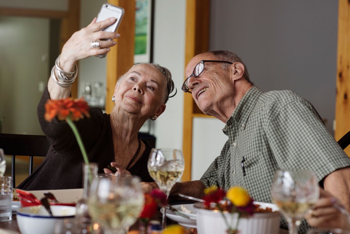 Senior couple taking selfie through smart phone during Thanksgiving at home
szeniorok a neten lugas