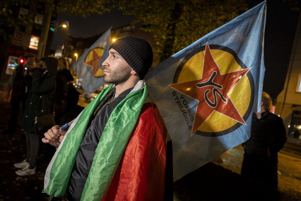 2023. október 12., Észak-Rajna-Vesztfália, Duisburg: Egy résztvevő Fiatal Küzdelem zászlóval és palesztin zászlóval a vállán áll a palesztin-barát tüntetésen. (Fotó: dpa Picture-Alliance /AFP/%Christoph Reichwein)