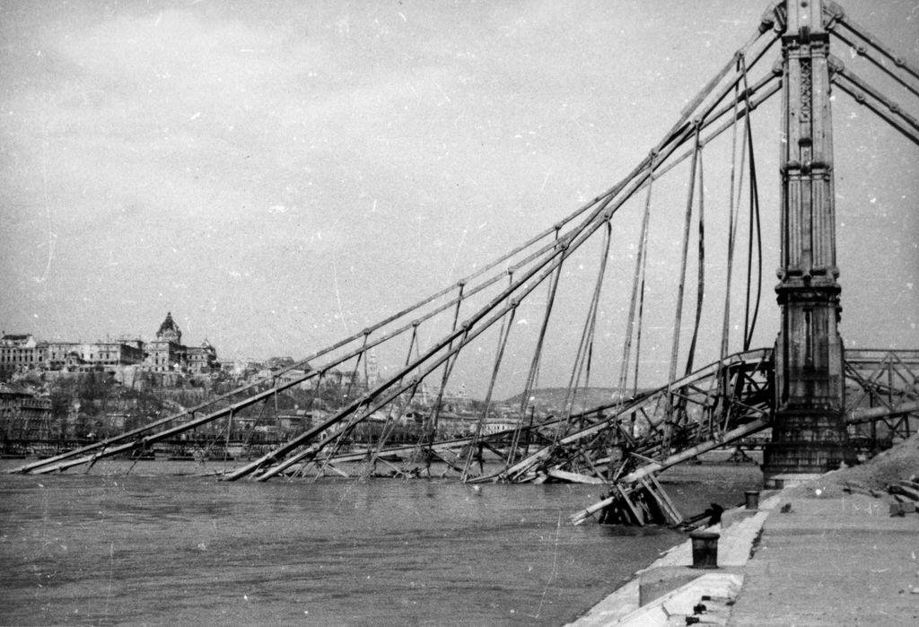 1945. Budapest V.
a lerombolt Erzsébet híd pesti hídfője az alsó rakpartról nézve, háttérben a romos Királyi Palota (később Budavári Palota).
Fortepan / Kramer István dr