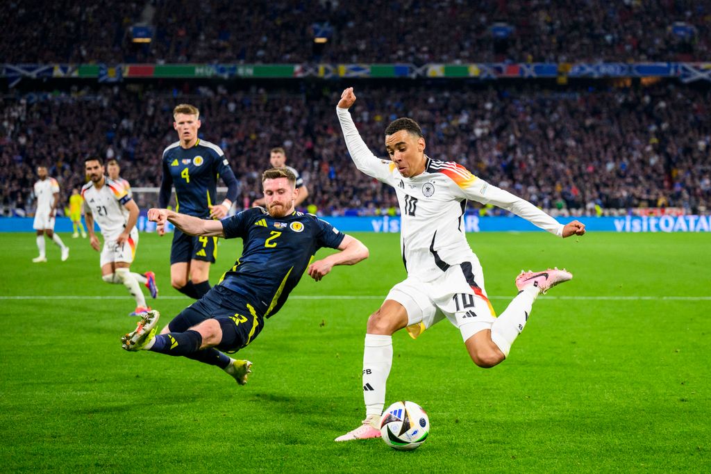 Euro2024: Germany - Scotland
14 June 2024, Bavaria, Munich: Soccer: UEFA Euro 2024, European Championship, Germany - Scotland, preliminary round, Group A, matchday 1, Munich Football Arena, Germany's Jamal Musiala (r) in action against Scotland's Anthony Ralston (l). Photo: Tom Weller/dpa (Photo by Tom Weller / DPA / dpa Picture-Alliance via AFP)