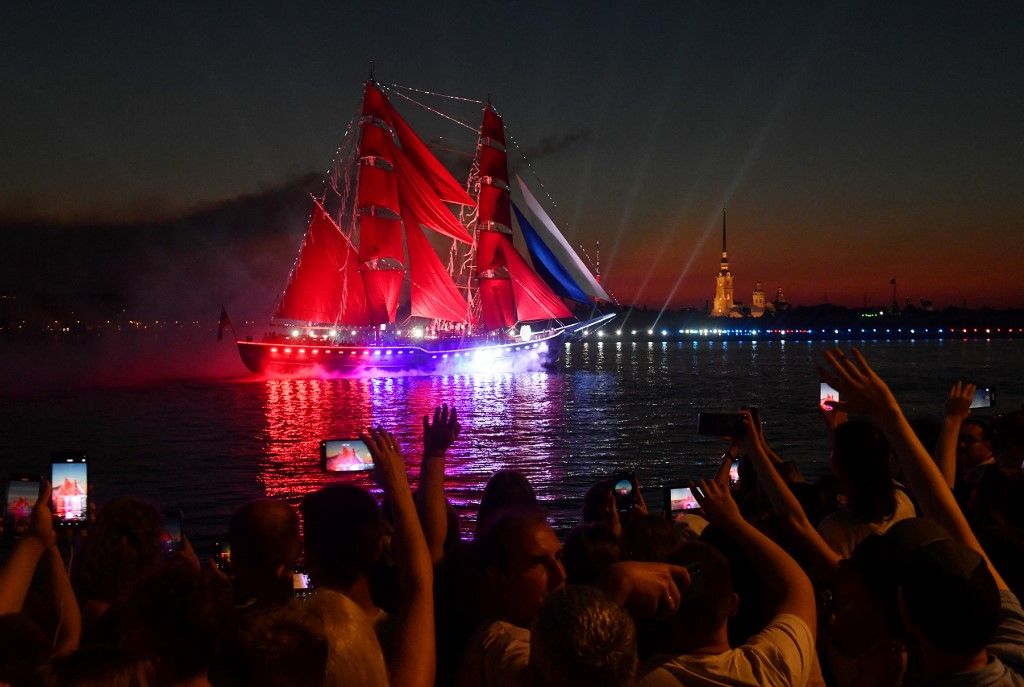 A "Rosszija" (Oroszország) nevű fregatt skarlátvörös vitorlákkal úszik a Neva folyón Szentpétervár belvárosában 2024. június 29-én kora reggel a "Skarlátvörös vitorlák" fesztiválon, amelyen a végzős középiskolások tiszteletére tartanak ünnepséget. 