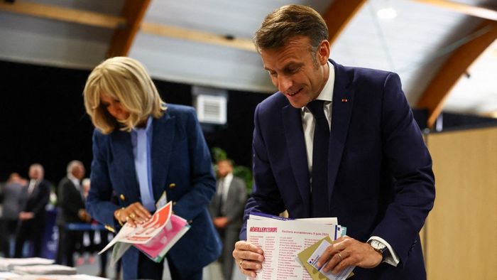 Emmanuel Macron francia elnök és a francia elnök felesége, Brigitte Macron szavazólapokat tartanak a kezükben az európai parlamenti választáson való szavazás előtt egy szavazóhelyiségben az észak-franciaországi Le Touquet-ban 2024. június 9-én