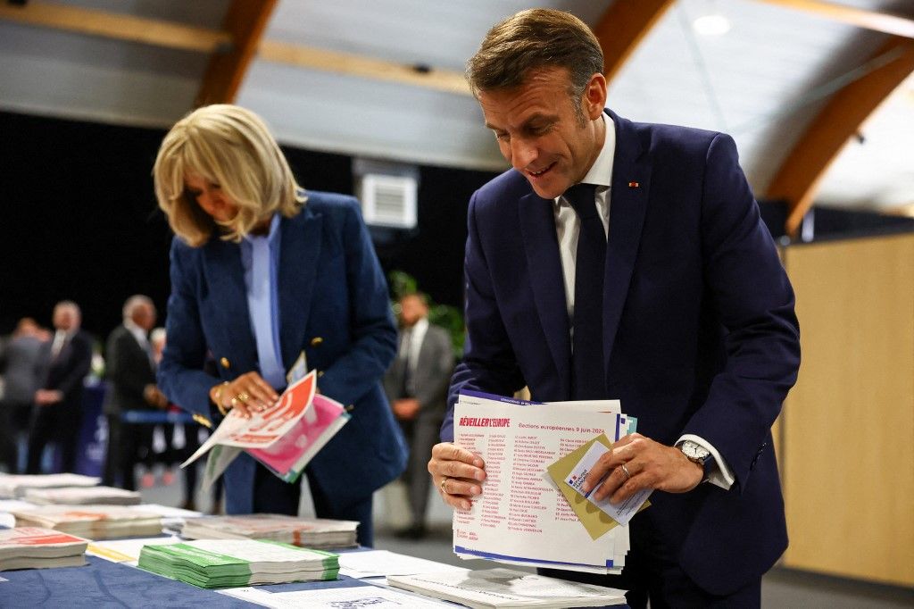 Emmanuel Macron francia elnök és a francia elnök felesége, Brigitte Macron szavazólapokat tartanak a kezükben az európai parlamenti választáson való szavazás előtt egy szavazóhelyiségben az észak-franciaországi Le Touquet-ban 2024. június 9-én