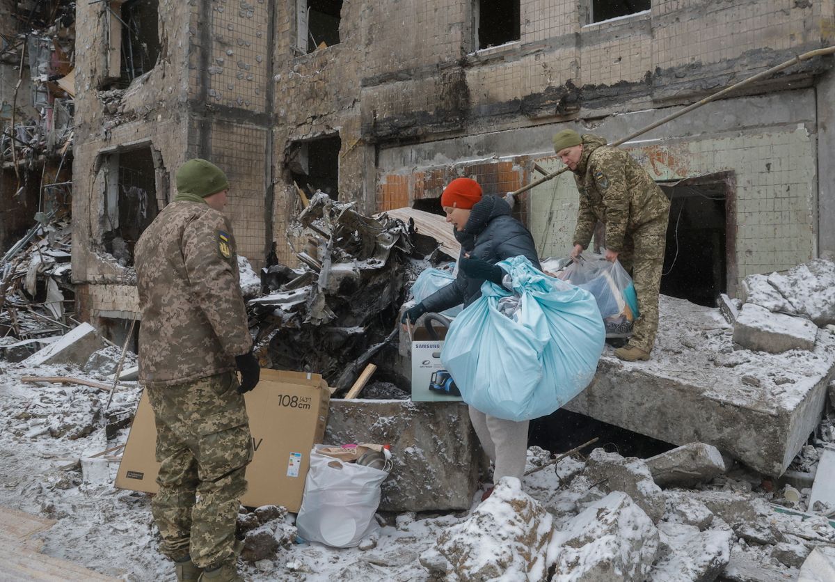 Romos házból kiköltöző lakónak segítenek katonák Kijevben az ukrán fővárost elõző nap ért orosz rakétatámadás után, 2024. január 3-án 